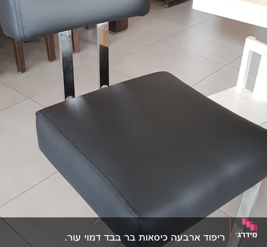 כיסא מרופד עם ריפוד שחור על רגלי מתכת